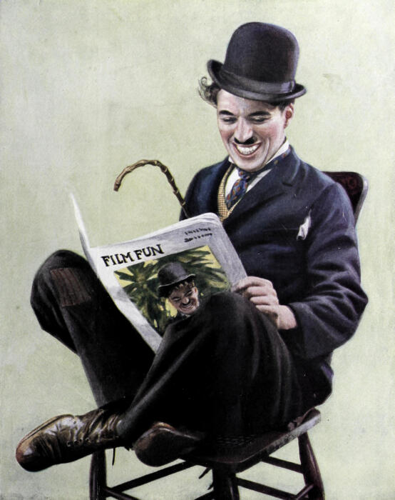 Ein Bild von Charlie Chaplin auf einem Stuhl mit einer Zeitung in der Hand.